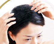 スカルプフォースエキスで頭皮マッサージをする女性